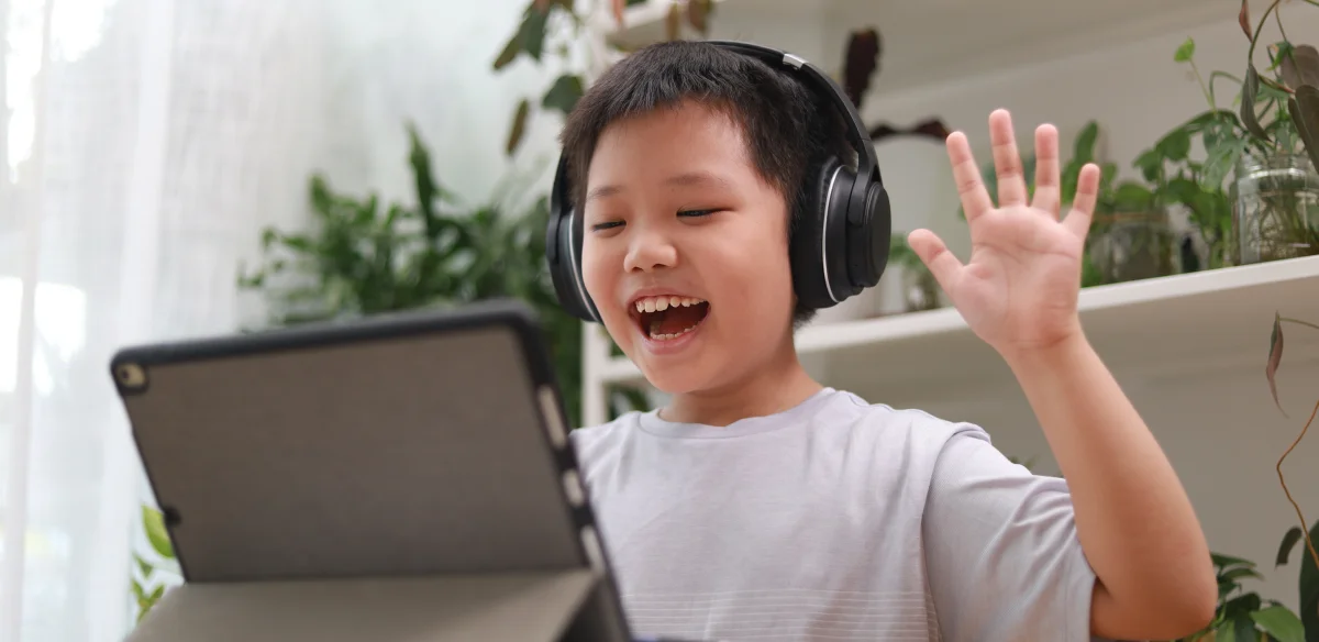Estudiante de primaria que asiste a una clase por Internet con unos auriculares negros