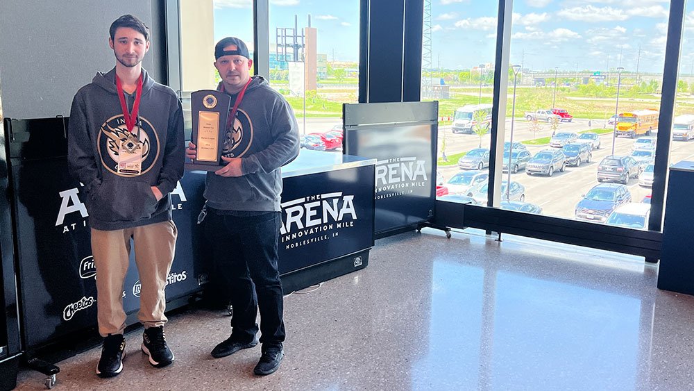Danny Patton, coordinador de clubes y deportes electrónicos de la INGDA, y Landon Kerkes, estudiante de último curso de la INGDA, posan con el trofeo de subcampeones estatales de Rocket League. (Foto del reportero)