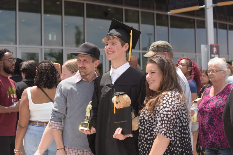 chico recién graduado con su familia
